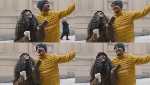 年轻微笑的女人和男人在城市的雪下感受幸福和爱高清在线视频素材下载