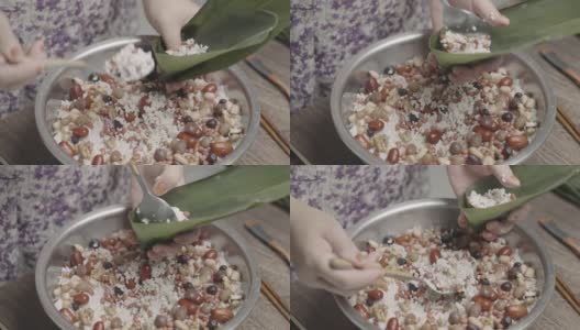 端午节期间，年长的亚洲妇女忙着用米肉蛋包粽子，这是中国的亚洲食品高清在线视频素材下载