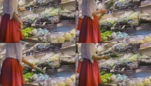 女子选择芹菜韭菜在有机蔬菜部冰箱。女性客户购买高清在线视频素材下载