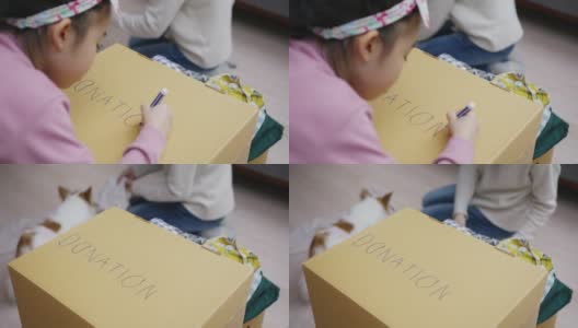 亚洲小孩写和画捐赠的盒子，衣服包装在家里高清在线视频素材下载