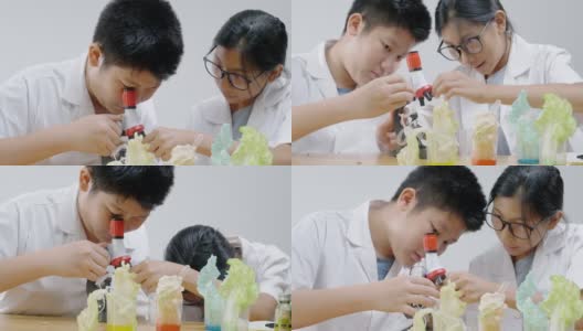 亚洲儿童穿着实验室大褂，使用显微镜进行科学实验，在家校实验室教育生活方式理念。高清在线视频素材下载