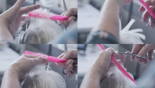 一个专业护理发型师剪一个高级妇女的灰色和白色头发的近距离手持式拍摄高清在线视频素材下载
