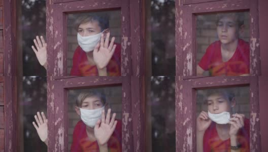 严肃的男孩戴着医用口罩看向窗外，摘下口罩，疫情结束高清在线视频素材下载