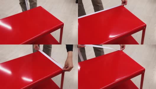 一个女人在宜家店里测量红色桌子的尺寸高清在线视频素材下载