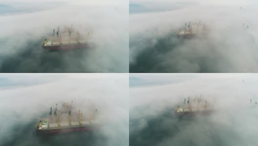 在保加利亚瓦尔纳海港，无人机拍摄的大雾中的货船和工业起重机高清在线视频素材下载