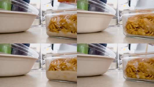 添加豆浆到玻璃容器与早餐谷物玉米片特写高清在线视频素材下载