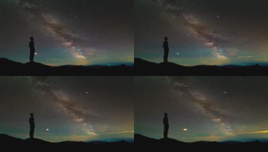 孤独的人站在繁星满天的山顶。间隔拍摄高清在线视频素材下载