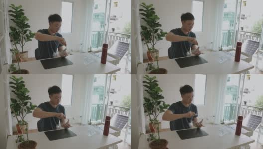 一名亚洲男子正在制作一个可回收的塑料瓶，用于拍摄植物储存视频高清在线视频素材下载