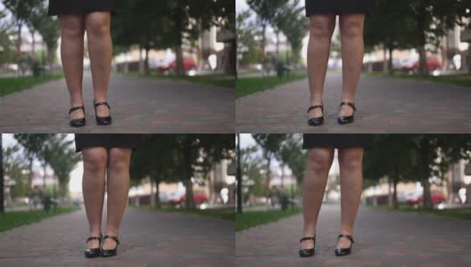 大码腿难以辨认的自信女人在人行道上慢动作跳舞。成年白人女商人穿着高跟鞋和黑色裙子在城市里享受快乐的一天。高清在线视频素材下载