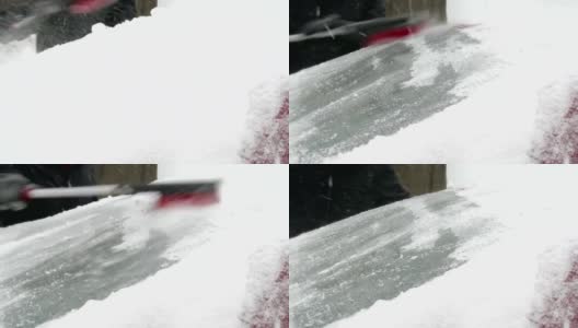 男人清理车上的雪高清在线视频素材下载