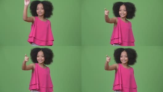 年轻可爱的非洲女孩与非洲式的头发指着手指高清在线视频素材下载
