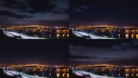 在海面上亮着灯的桥和高速公路上行驶的汽车和停泊在码头的帆船高清在线视频素材下载