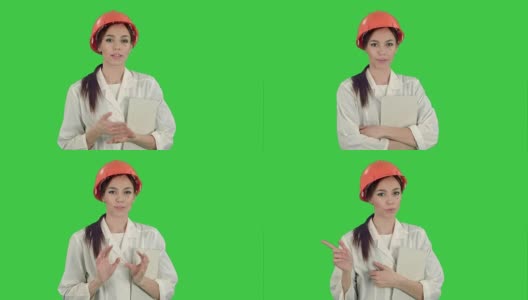 戴安全帽的女建筑师拿着平板电脑，在绿屏上对着摄像头说话高清在线视频素材下载