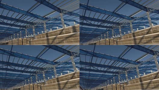 现代仓库的建筑工地，钢结构的新商业建筑，以清澈的蓝天为背景，建设一个现代化的工厂或仓库高清在线视频素材下载