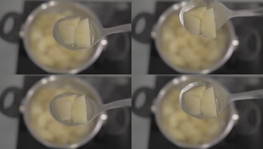 用汤勺将煮熟的土豆切片，放在土豆锅的背景上。4 k。4 k的视频高清在线视频素材下载