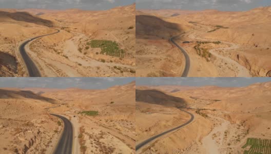 沙漠山丘上的高速公路，用无人机拍摄。空旷的公路，美丽的自然景观。中东沙漠中的国王公路。高清在线视频素材下载