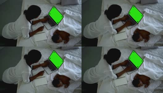 4K黑人女性使用绿色屏幕的笔记本电脑照看新生儿高清在线视频素材下载