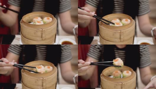 亚洲妇女吃蒸点心(中国菜)。高清在线视频素材下载