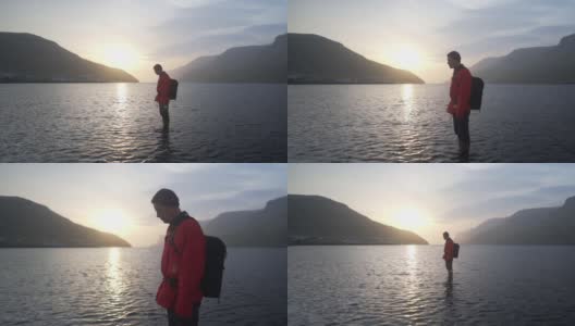日出时，一名男子往浅水里看高清在线视频素材下载