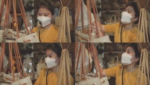 成年成熟的亚洲女性执拗口罩防毒购物手挑传统老藤包产品旅游理念高清在线视频素材下载