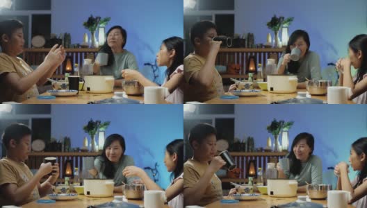 亚洲家庭的母亲和孩子晚上在家里一起吃涮锅或寿喜烧，生活理念。高清在线视频素材下载