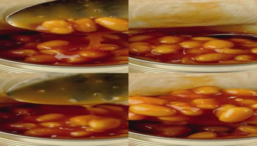 勺子从金属罐头里取出番茄酱炖豆。高清在线视频素材下载