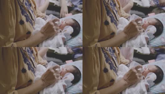 亚裔祖母用奶瓶喂新生儿。高清在线视频素材下载
