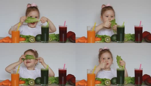 饮食、排毒、素食主义和健康生活方式的概念。小女孩喝蔬菜冰沙-胡萝卜，甜菜和绿色。一个可爱的婴儿吃莴苣叶高清在线视频素材下载