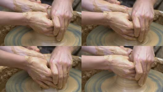 两只手交织在一起，在陶工转盘上形成一个陶罐。高清在线视频素材下载