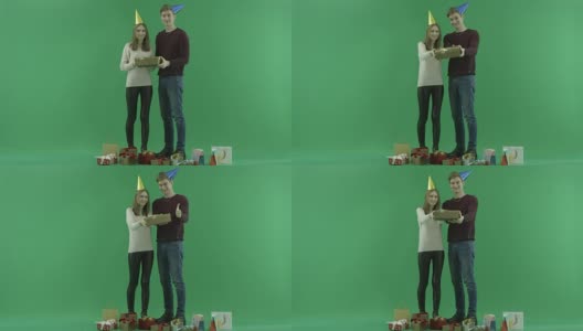 年轻夫妇向相机展示圣诞礼盒，背景上的色度键高清在线视频素材下载
