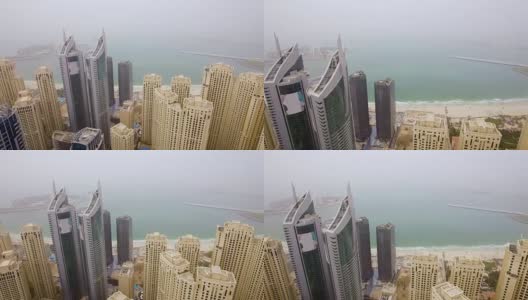 鸟瞰图的阵列摩天大楼面对大海在小雾。阿拉伯联合酋长国迪拜高清在线视频素材下载