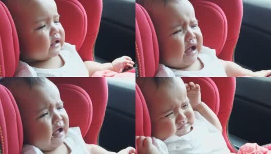 悲伤的婴儿在驾驶途中在红色的汽车座椅上哭泣高清在线视频素材下载