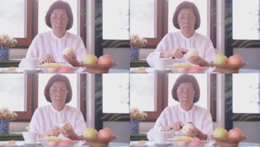 退休妇女在家厨房切苹果高清在线视频素材下载