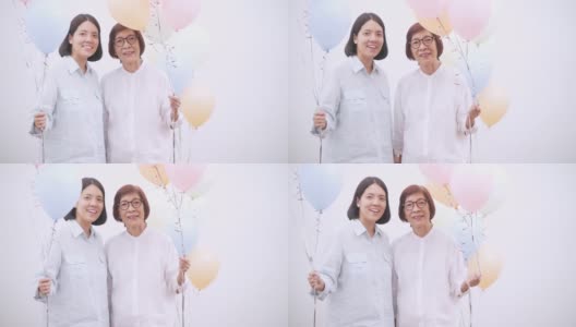 亚洲活跃的老年妇女与她的中年女儿与彩色气球。快乐的老年人生活方式高清在线视频素材下载