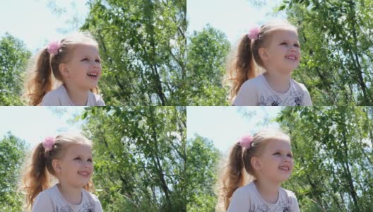 一个可爱快乐的女孩的肖像看着一边。观察自然。宝宝的积极情绪。一个快乐的孩子的微笑。高清在线视频素材下载