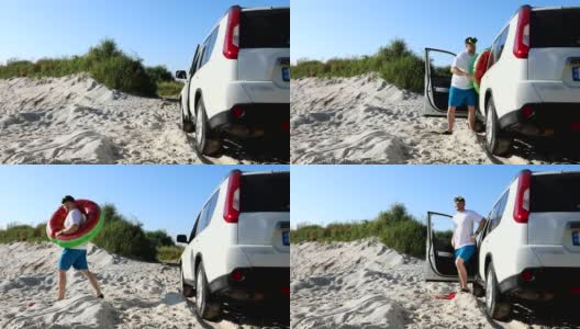 沙滩上，一个男人穿着拖鞋从车里出来高清在线视频素材下载