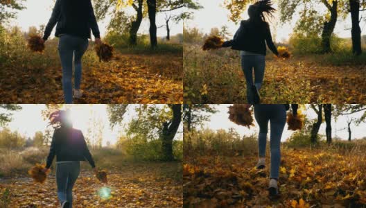 年轻女子奔跑在秋天的森林里，手里拿着黄叶的花束。女孩在色彩斑斓的秋天森林里玩，生动的落叶。明亮的阳光照在背景上。慢动作高清在线视频素材下载