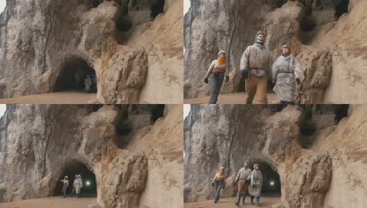 年轻的探险家戴着头盔从黑暗的大洞穴里走出来高清在线视频素材下载