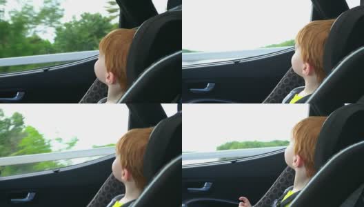 快乐的蹒跚学步的男孩安全在汽车座位上的公路旅行高清在线视频素材下载