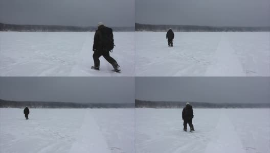 俄罗斯鄂毕河水库，一名背着背包的男子在暴风雪中行走高清在线视频素材下载