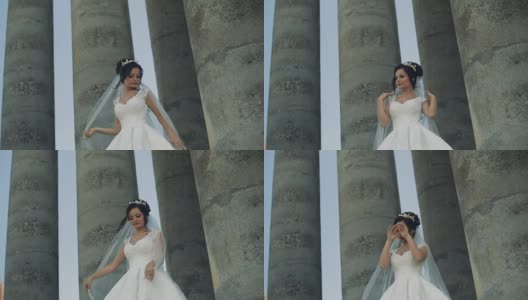 美丽可爱的新娘站在古老的柱子旁高清在线视频素材下载