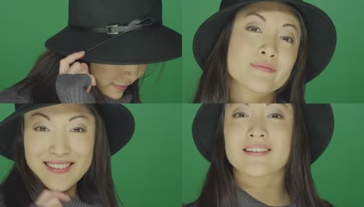 美丽的年轻亚洲女人在一顶帽子微笑和调情，在一个绿色屏幕工作室的背景高清在线视频素材下载