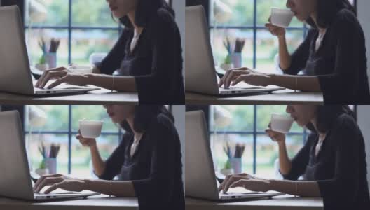 远程工作在家办公概念。女商人通过笔记本电脑在网上工作，喝着咖啡。亚洲年轻企业家观看网络研讨会，并在与团队的视频会议中交谈高清在线视频素材下载