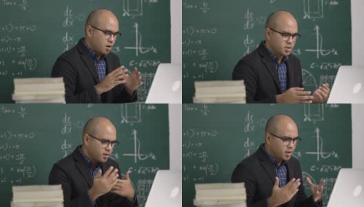 印度年轻教师男子坐着用笔记本电脑进行在线视频会议直播。亚洲数学教师在线授课，供学生在线学习。高清在线视频素材下载