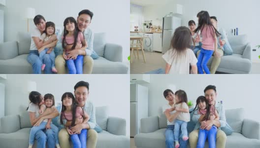 亚洲幸福家庭的肖像花时间与孩子一起在家里。年轻可爱的小女孩和父母坐在沙发上微笑着，看着摄像机在客厅里。活动关系的概念高清在线视频素材下载