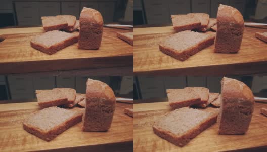 农场面包躺在厨房的一块木板上。早餐切成的酸面包片。移动滑块极端接近股票镜头高清在线视频素材下载