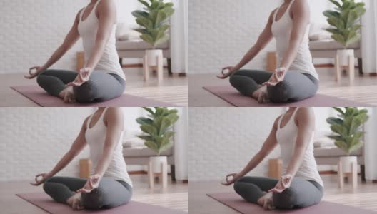 亚洲妇女在家里练习冥想瑜伽。高清在线视频素材下载