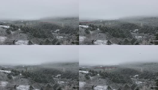 红火车在冬天的雪山下的桥上高清在线视频素材下载