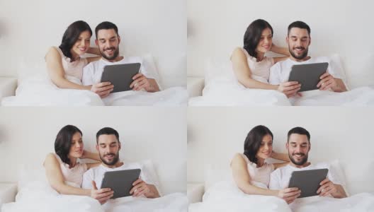 微笑的夫妇在床上与平板电脑高清在线视频素材下载