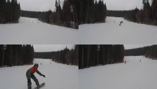 滑雪者和滑雪板运动员沿着滑雪坡下滑。高清在线视频素材下载